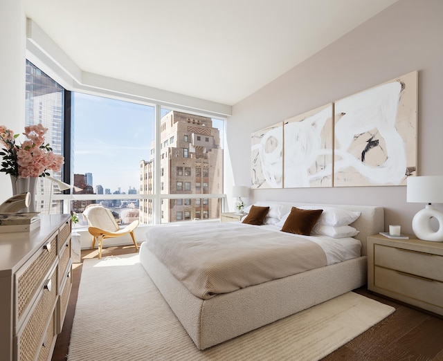 bedroom with a view of city and wood finished floors