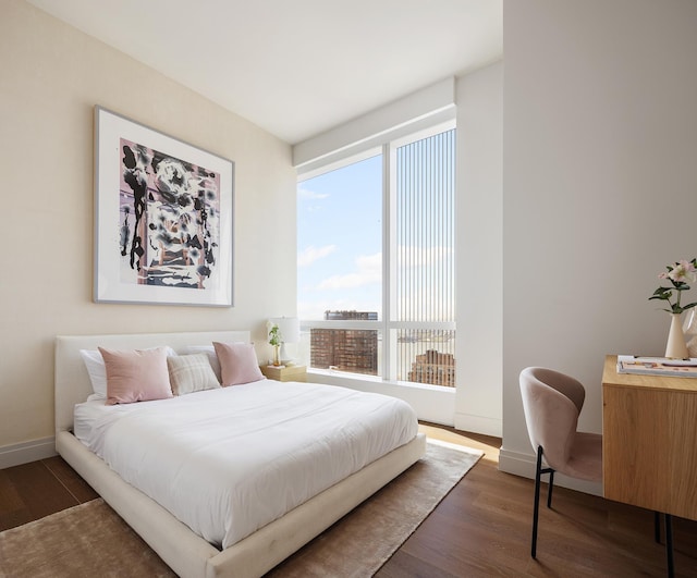 bedroom with baseboards and wood finished floors