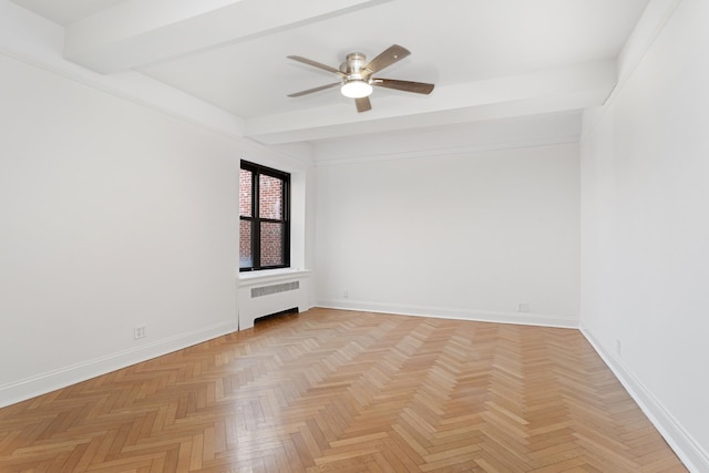 spare room featuring radiator, ceiling fan, baseboards, and beam ceiling