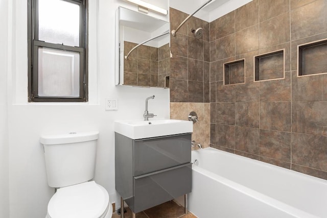 full bathroom featuring toilet, vanity, and tiled shower / bath