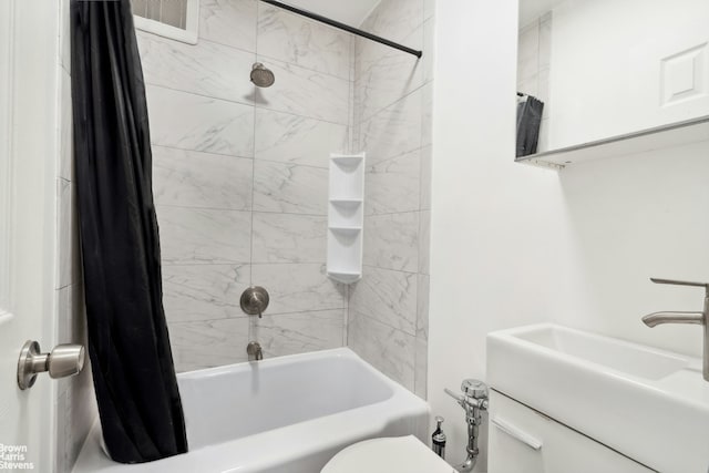 bathroom featuring shower / tub combo with curtain, a sink, and toilet