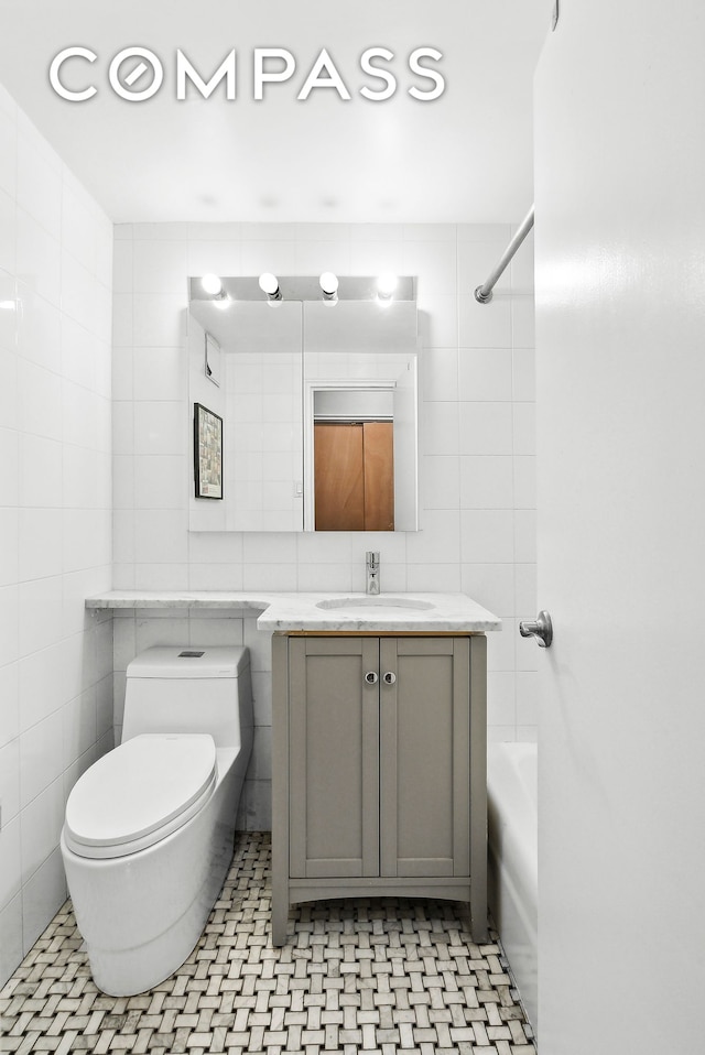 full bathroom featuring tub / shower combination, toilet, tile walls, and vanity