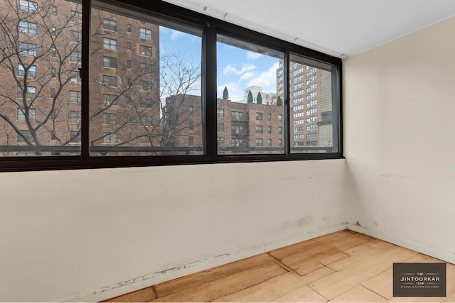 unfurnished room with hardwood / wood-style flooring