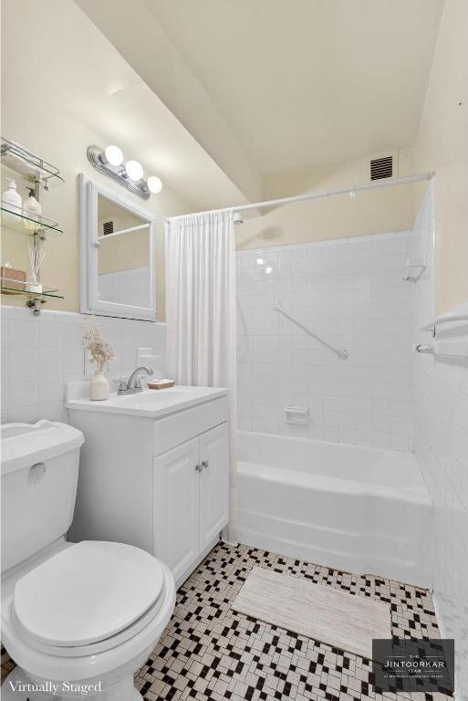 full bathroom featuring tile walls, shower / bath combination with curtain, tile patterned flooring, vanity, and toilet