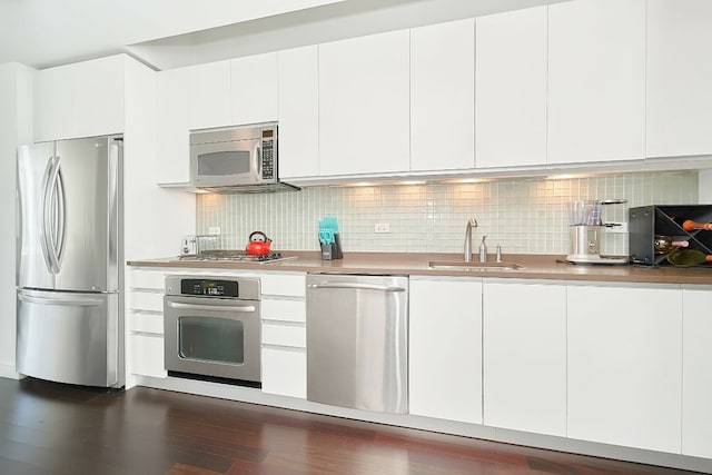 kitchen featuring white cabinetry, appliances with stainless steel finishes, sink, and backsplash