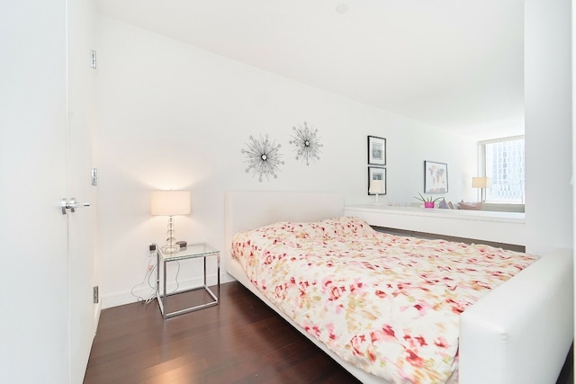 bedroom with dark wood-type flooring