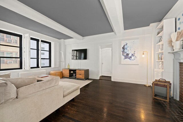 living room with beamed ceiling, dark hardwood / wood-style floors, radiator heating unit, and a fireplace