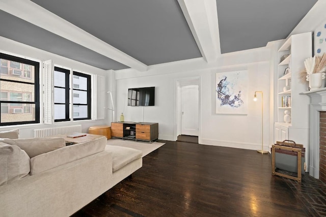 living room featuring beamed ceiling, radiator heating unit, dark wood-type flooring, and a brick fireplace