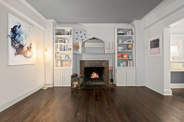 unfurnished living room featuring dark wood-type flooring, a fireplace, and built in features