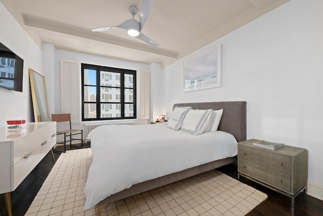 bedroom featuring ceiling fan, radiator heating unit, and wood finished floors