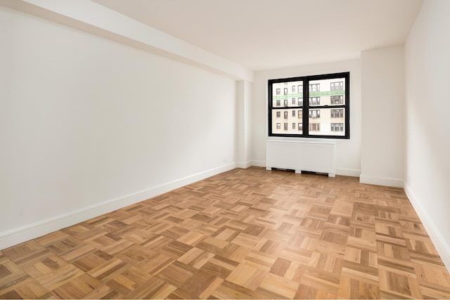 unfurnished room featuring baseboards and radiator heating unit