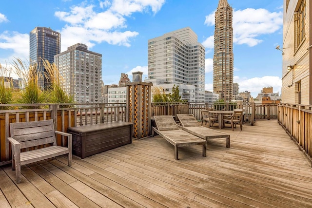 deck featuring a view of city and outdoor dining space