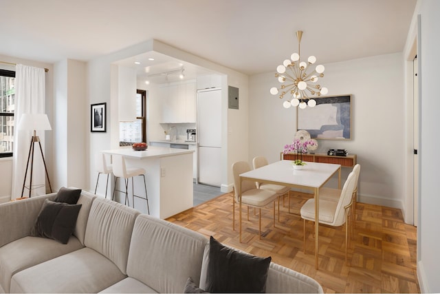 dining space with electric panel, a notable chandelier, baseboards, and rail lighting