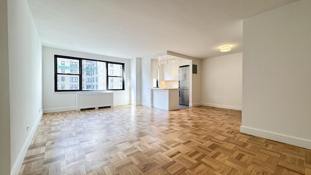 unfurnished living room with baseboards