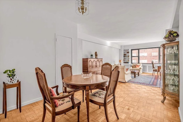 dining area featuring light parquet flooring and a chandelier