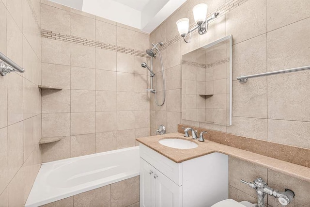 bathroom with tiled shower / bath and vanity