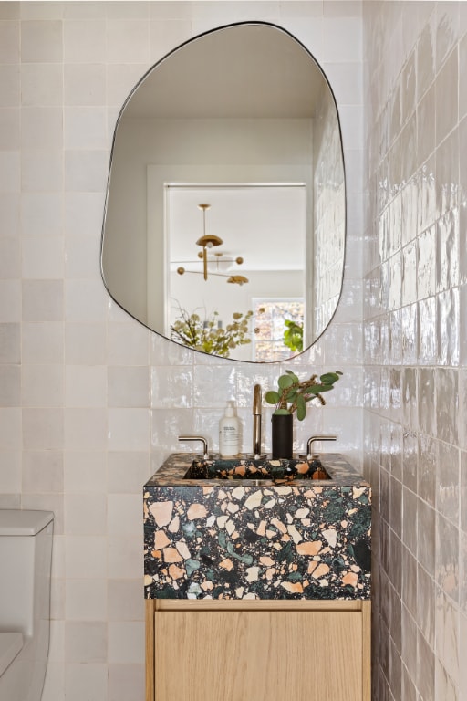 bathroom featuring decorative backsplash, tile walls, and toilet