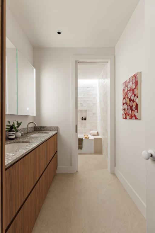 bathroom featuring a tub to relax in, vanity, and tile patterned flooring