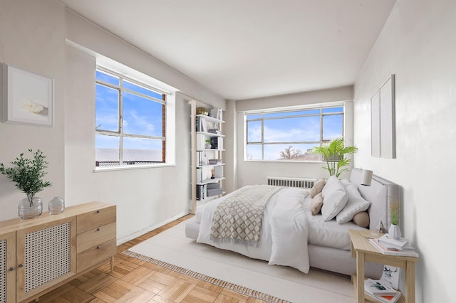 bedroom with multiple windows, radiator heating unit, and baseboards