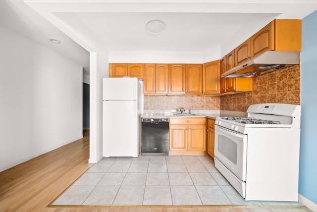 kitchen with sink, light tile patterned floors, backsplash, and white appliances