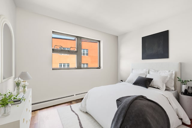 bedroom with light hardwood / wood-style flooring and a baseboard radiator