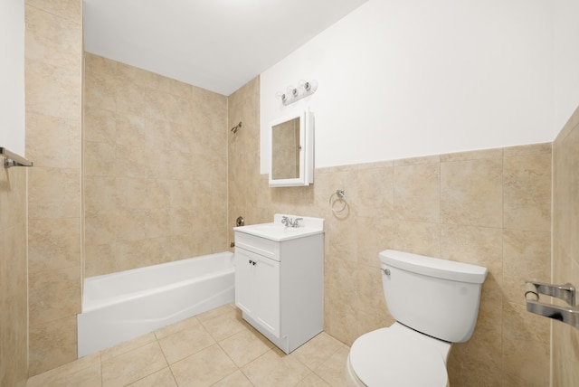 full bathroom with shower / bath combination, toilet, tile patterned flooring, vanity, and tile walls