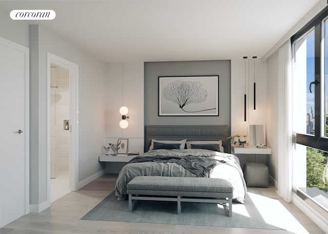 bedroom with ensuite bathroom and light wood-style flooring