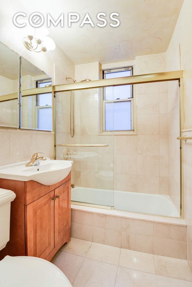 full bath with tile walls, toilet, tiled shower / bath, vanity, and backsplash