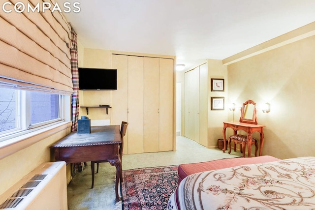 bedroom featuring light colored carpet and radiator