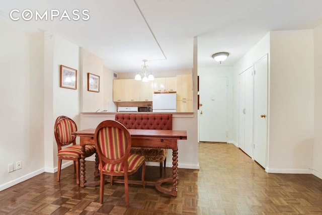 dining room with a chandelier and baseboards