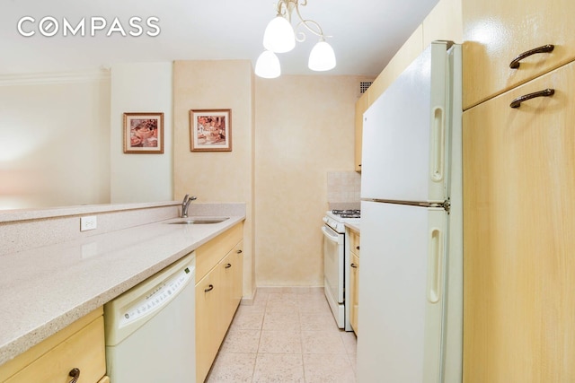 kitchen featuring light countertops, light brown cabinetry, light tile patterned flooring, a sink, and white appliances