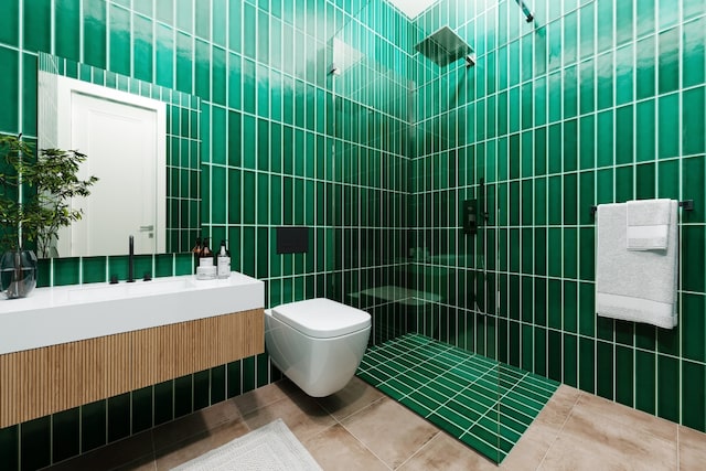 bathroom featuring tile patterned flooring, tile walls, tiled shower, vanity, and toilet