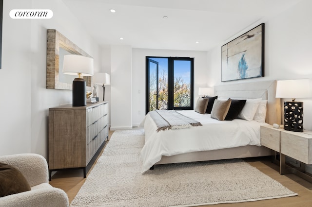 bedroom featuring access to exterior and light hardwood / wood-style flooring