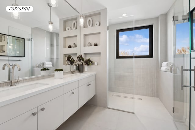 bathroom with tile patterned flooring, a shower with shower door, and vanity