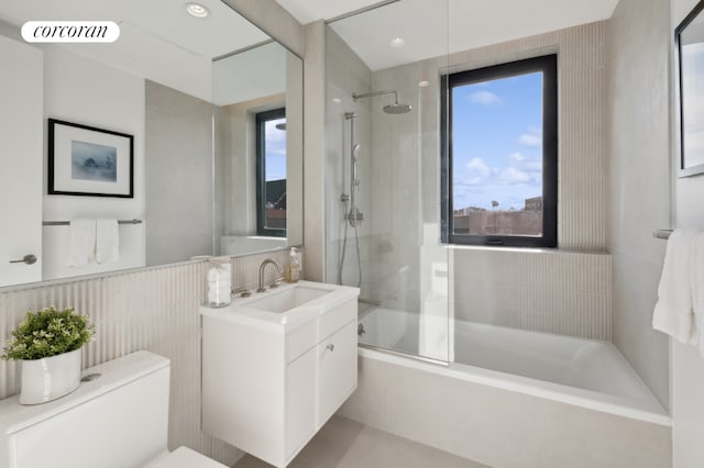 full bathroom with shower / bath combination with glass door, vanity, and toilet