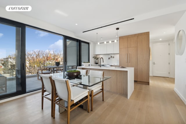 dining area with light wood-style flooring, visible vents, and recessed lighting