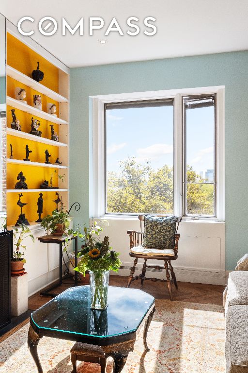 sitting room with built in shelves, plenty of natural light, and wood-type flooring