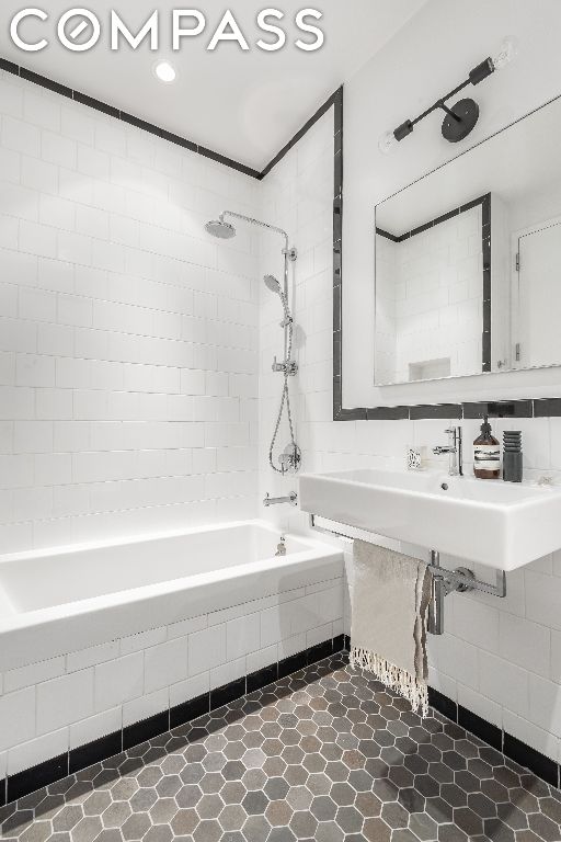 bathroom featuring tiled shower / bath, sink, and tile patterned floors