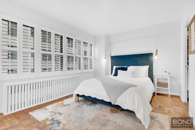 bedroom with radiator and parquet flooring