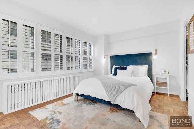 bedroom with parquet flooring and radiator heating unit