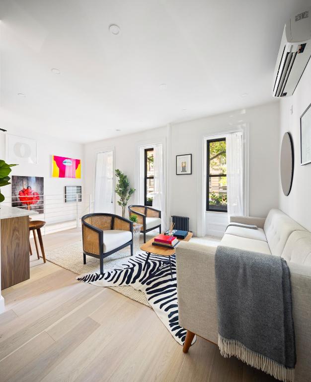 living room with a wall mounted AC and light wood-style flooring