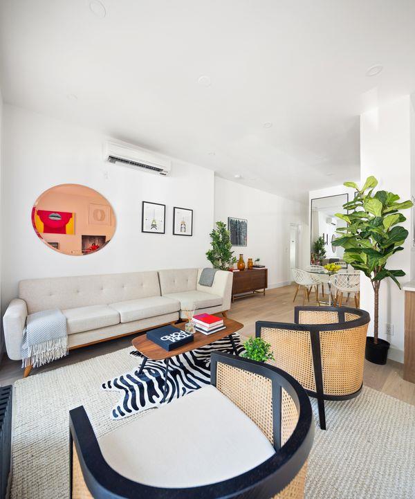 living room with light wood-style floors and an AC wall unit