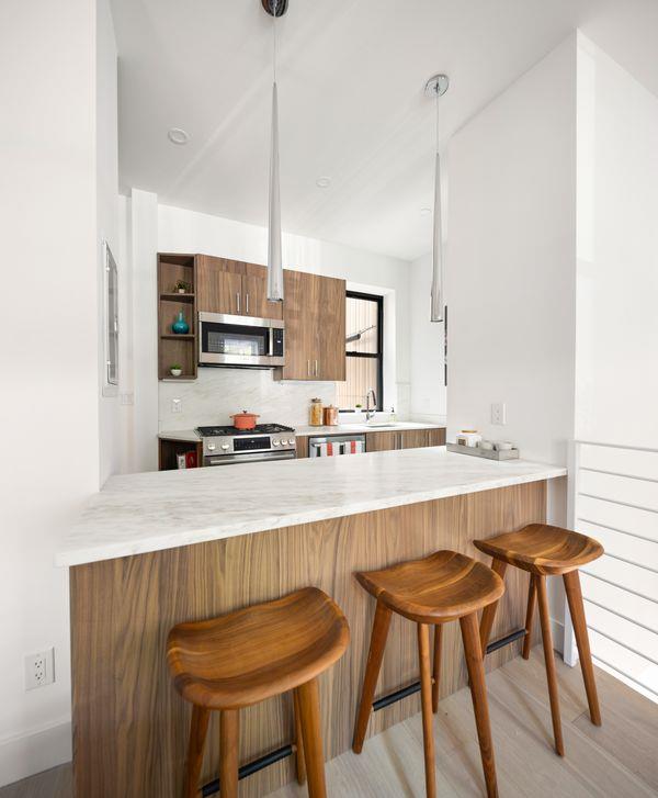 kitchen with stainless steel appliances, a peninsula, and brown cabinets