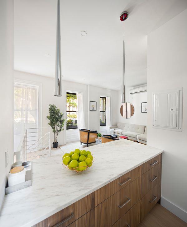 kitchen with light wood-style floors, brown cabinets, hanging light fixtures, and baseboards