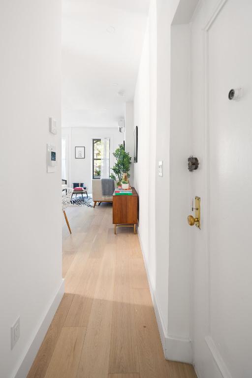 hallway with light wood-style flooring and baseboards