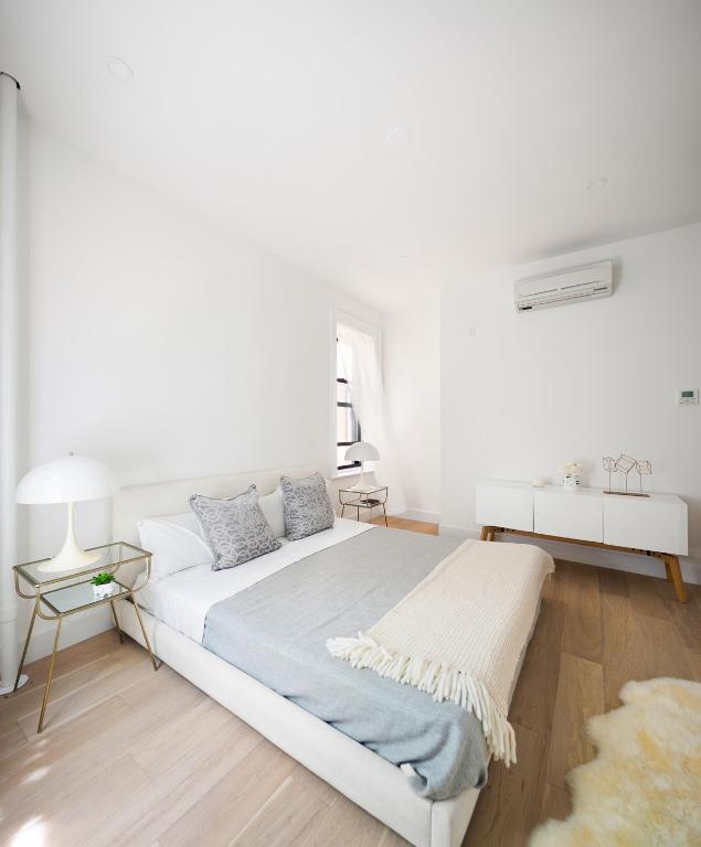 bedroom featuring light wood finished floors and a wall mounted air conditioner