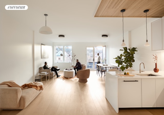 interior space with sink, white cabinetry, and pendant lighting