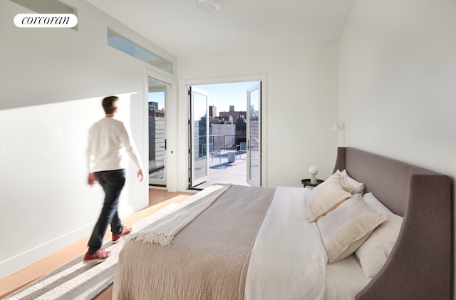 bedroom with light wood-type flooring and access to outside