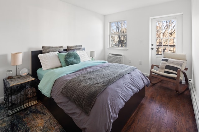 bedroom featuring a wall mounted air conditioner, dark wood-type flooring, and baseboard heating