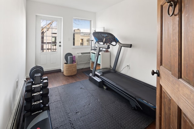 workout room with a wall mounted AC and dark hardwood / wood-style flooring